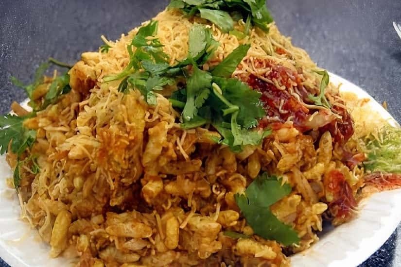 Bhel puri chaat topped with sev, onion and coriander